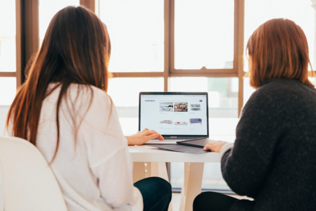 Two people looking at a laptop. Photo by Kobu Agency on Unsplash
